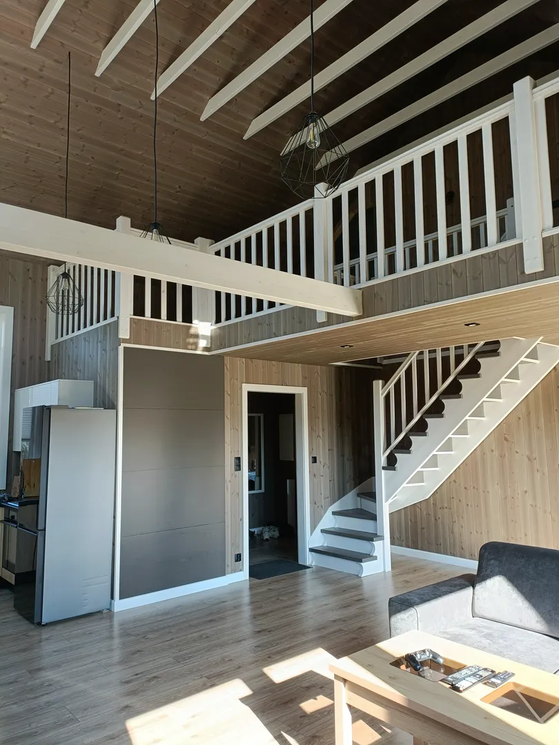 Salon z antresolą wykończony drewnem: ściany, sufit, schody – Wykończenia wnętrz