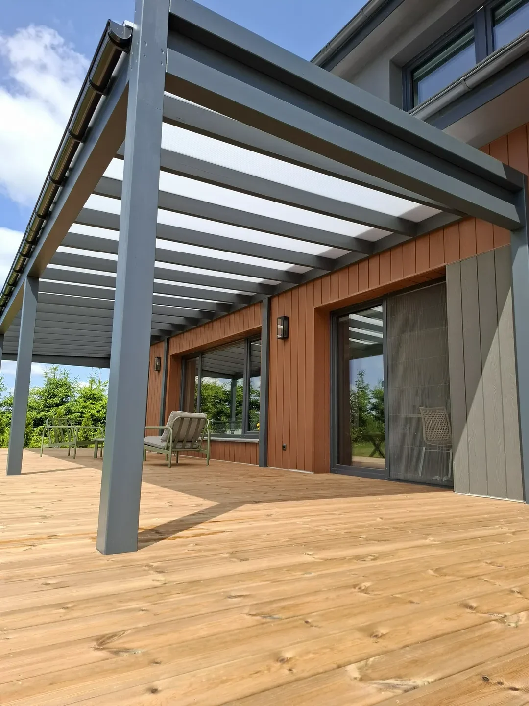 Zadaszenia tarasów: nowoczesna pergola na drewnianym tarasie przy domu