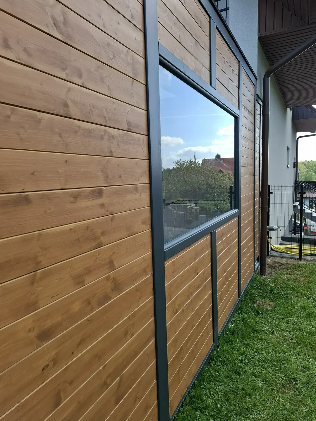 Elewacje drewniane budynku z poziomymi deskami i dużym oknem