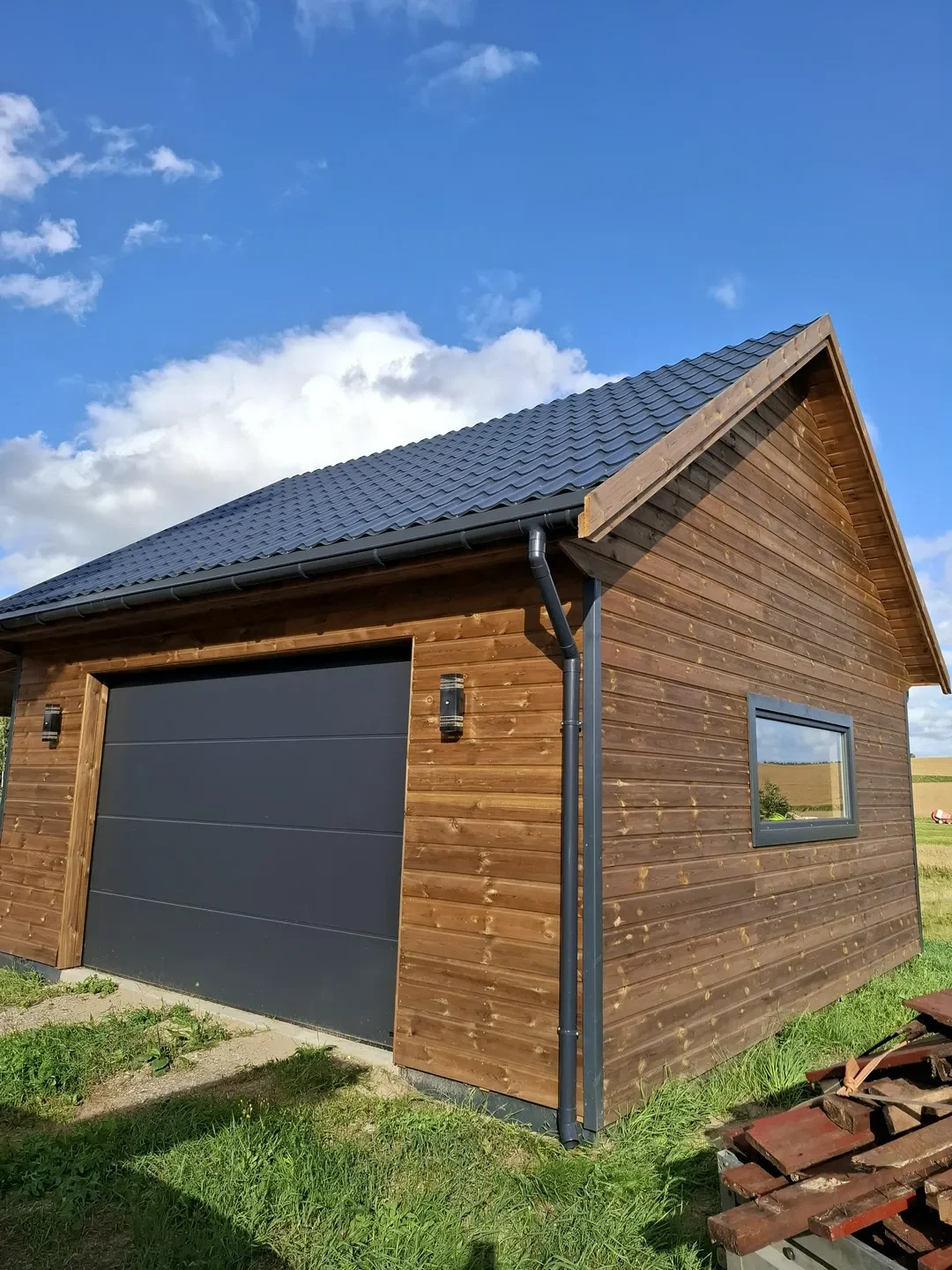 Drewniana wiata garażowa z bramą segmentową i oknem